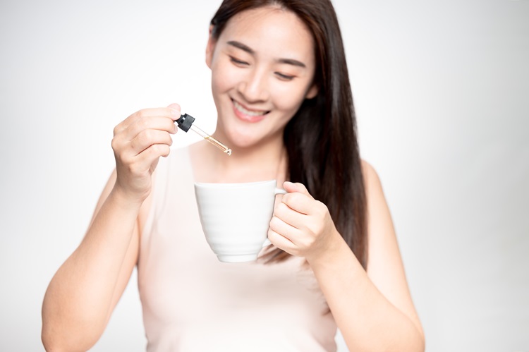 The young Asian woman is dosing her CBD correctly - starting with a small dose