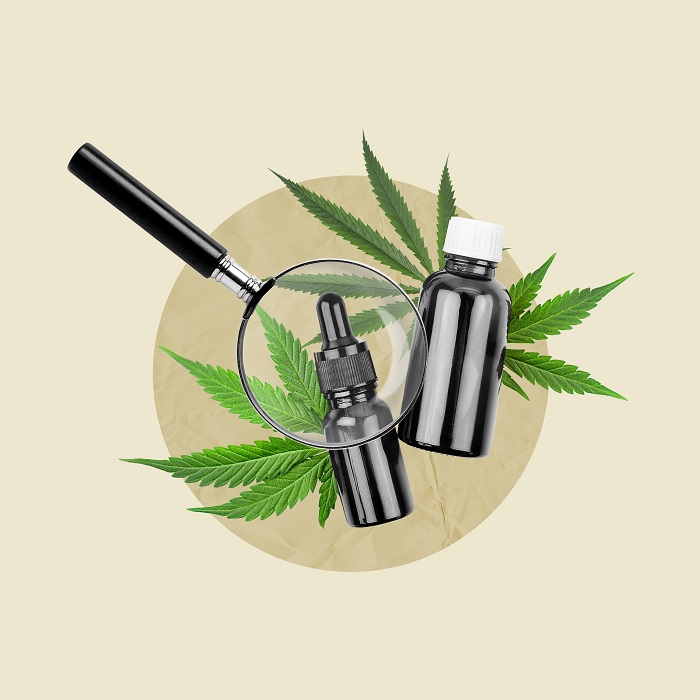 Produits THCO sous forme de flacons noirs et de feuilles de cannabis, sous grossissement